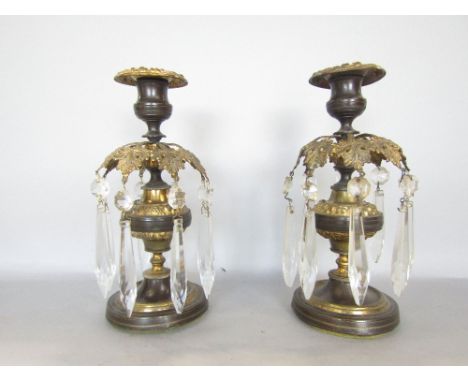 Pair of bronze and gilt metal lustre type candlesticks, with floral sconces and prismatic drops upon a shaped stem and steppe