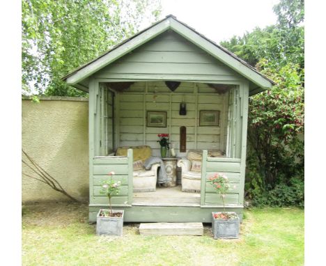 A vintage revolving summer house, circa.1930 with painted timber walls, beneath a cedar shingle roof - reconstructed and re-r