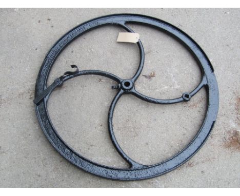 A vintage cast iron agricultural fly wheel, probably from a chaff cutter, approx 3ft diameter