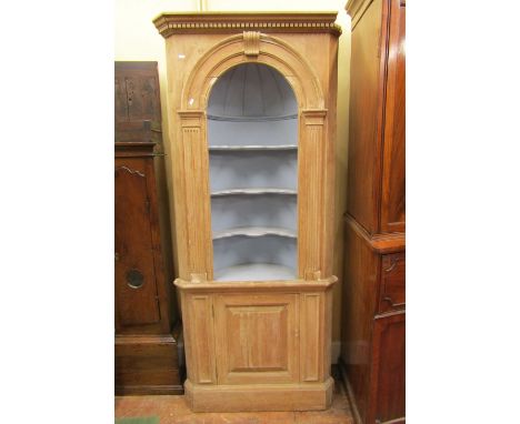 A Georgian style stripped pine framed barrel back freestanding corner cupboard, partially enclosed by a fielded panelled door