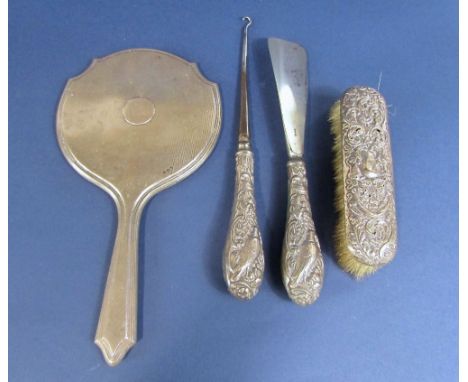 A collection of silver dressing set items to include an engine turned silver hand mirror, a silver dressing brush, together w