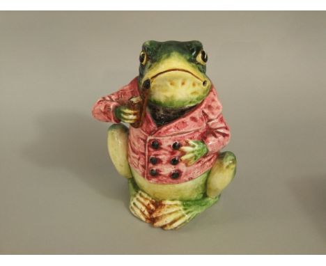 A late 19th century continental tobacco jar and cover in the form of a pipe smoking frog in a pink jacket, with impressed num