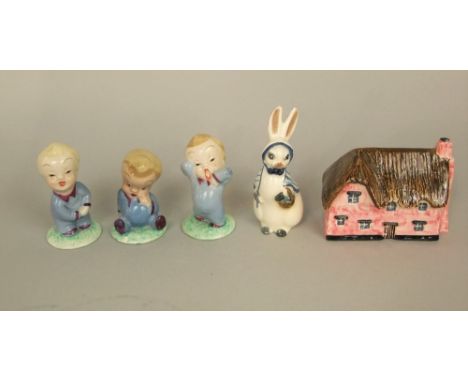 A set of three Wade nursery figures of Wynken, Blynken and Nod, a ceramic figure of a rabbit in blue and white shawl and bonn