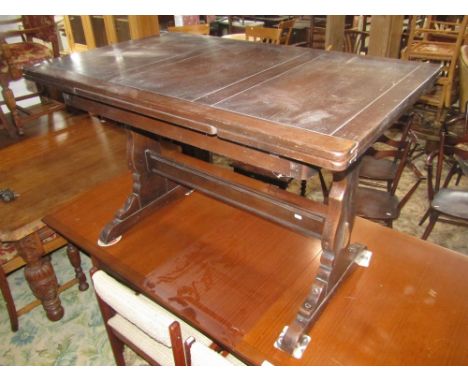 An Ercol dark stained elm drawer leaf dining table raised on shaped supports united by a central stretcher together with a se