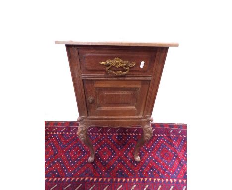 A 19th century oak bedside/lap table, the front elevation enclosed by a panelled door and frieze drawer with carved cabriole 