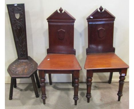 A pair of mid Victorian hall chairs, the backs of architectural form, raised on turned supports
