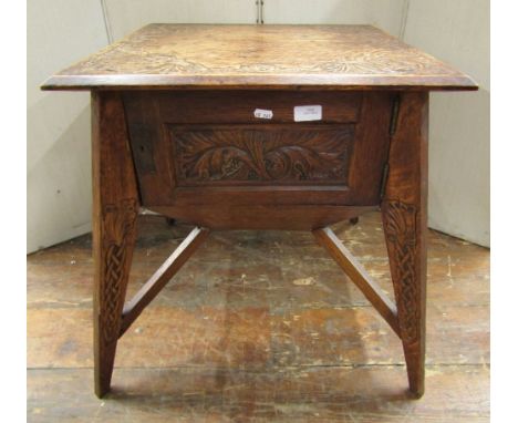 An unusual Arts &amp; Crafts oak centre/sewing table raised on four splay and tapering supports enclosed by a panelled door e