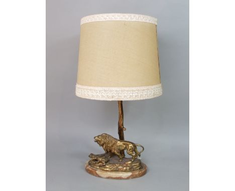 Gilt cast metal figural table lamp depicting a rampant lion over prey, the column in the form of a tree upon a marble base, 5