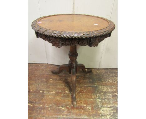 A 19th century oak occasional table, the circular top within a carved trail of oak leaves and acorns, over a further carved f