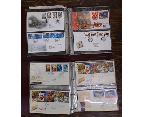 Two albums containing a quantity of Royal Mail First Day Covers including some with associated commemorative coins (2)
