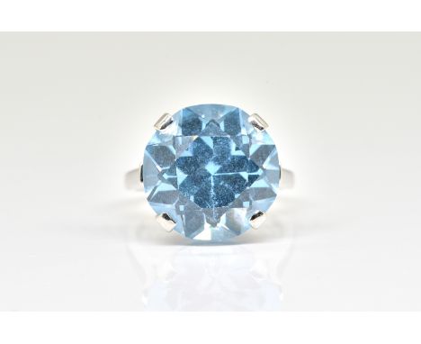 A WHITE GOLD AND SYNTHETIC BLUE SPINEL SOLITAIRE RINGClaw set with a circular cut synthetic blue spinel, detailed 14 K, ring 