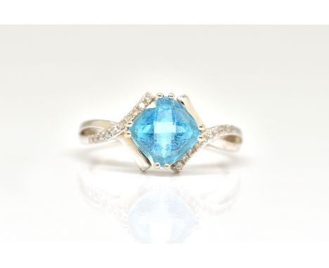 AN 18CT WHITE GOLD, BLUE TOPAZ AND DIAMOND RINGClaw set with the square cut blue topaz between diamond shoulders, in a twist 