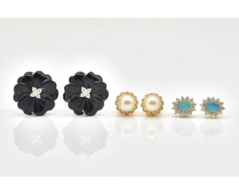 THREE PAIRS OF EARRINGSComprising a pair of carved onyx and diamond flower earrings, marked 750, pair of opal and diamond clu