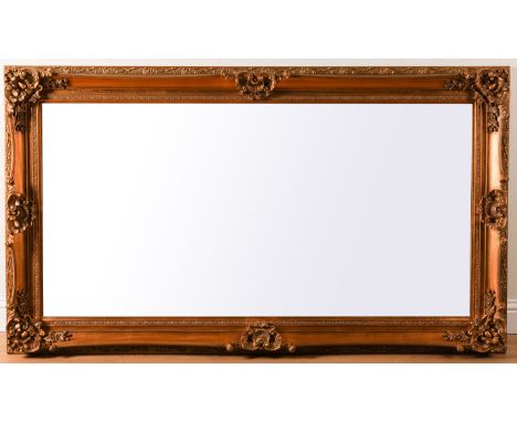 A MODERN GILT FRAMED BEVELLED GLASS MIRROR WITH FLORAL MOULDED FRAME210 cm wide; 121cm cm high