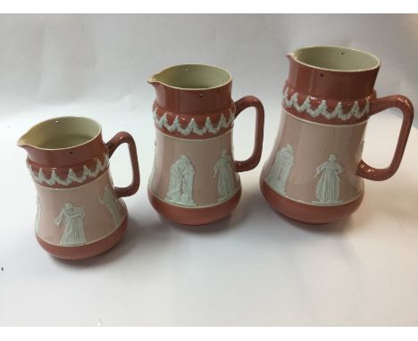 A collection of three graduated Carltonware jugs decorated with neo classical figures and one other Doulton jug also decorate