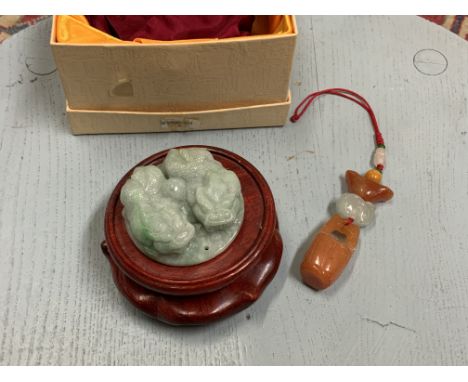 A modern Chinese green jade carved amulet on wooden stand together with a hardstone key ring