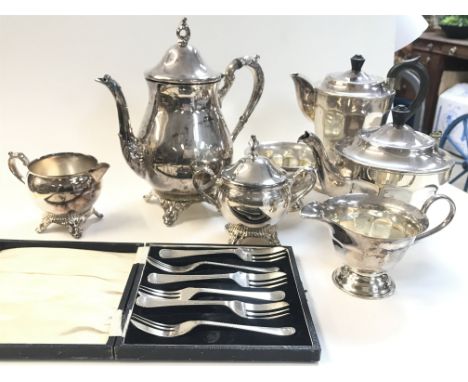 A collection of silver plated items including a tea and coffee service of scalloped form, cased forks etc.