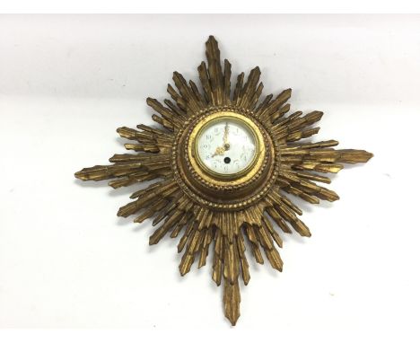 A gilt sunburst wall clock. Approx 40cm diameter.