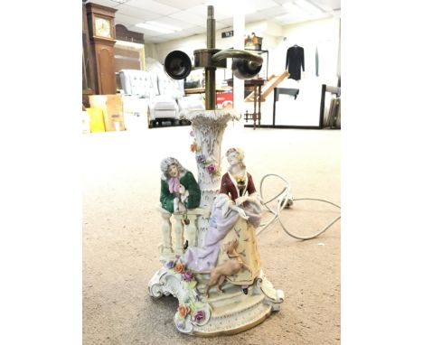 A porcelain lamp decorated with figures , some damage