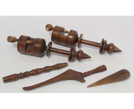 Pair of treen turned walnut bobbin or spool winding clamps, each 28cm long; a carved knitting stick, 26cm long; another of tu