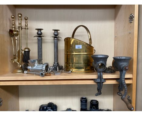 A Shelf of collectables to include two metal Corinthian column candle sticks, Brass helmet coal scuttle, Brass companion set 