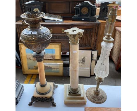 Three antique paraffin lamp bases. Includes onyx and brass Corinthian column bases and brass and glass base. 