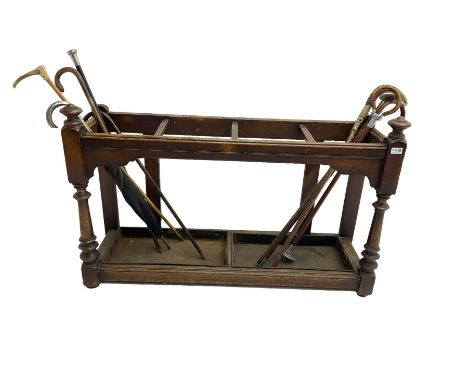Edwardian oak hallway stick and umbrella stand, four divisions on turned supports, with metal tray liners and various sticksD