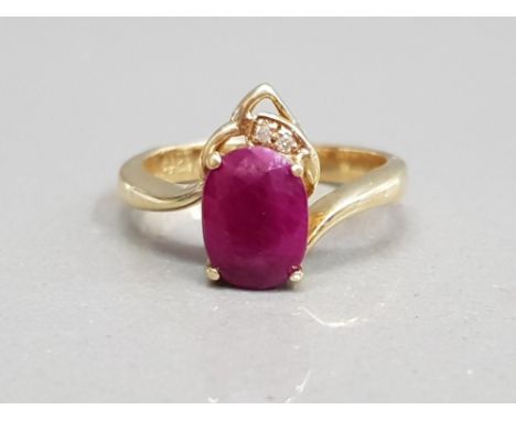 14CT YELLOW GOLD RUBY AND DIAMOND ORNATE RING A OVAL SHAPED RUBY SET WITH TWO BRILLIANT ROUND CUT DIAMONDS J1/2 3.3G GROSS
