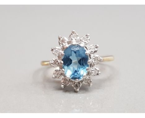 9CT YELLOW GOLD BLUE TOPAZ AND DIAMOND CLUSTER RING FEATURING AN OVAL SHAPED BLUE TOPAZ STONE IN THE CENTRE SURROUNDED BY DIA