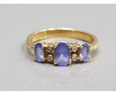 18CT YELLOW GOLD PURPLE STONE AND DIAMOND RING COMPRISING OF 3 OVAL PURPLE STONES SET WITH TWO DIAMOND EITHER SIDE OF THE CEN