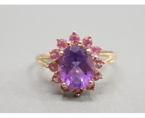 9CT YELLOW GOLD AMETHYST AND PINK STONE CLUSTER RING FEATURING A PURPLE STONE SET IN THE CENTRE SURROUNDED BY PINK STONES SIZ