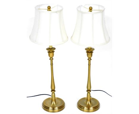 A pair of burnished brass candlestick formed table lamps, with white octagonal shades, 84cm high. 
