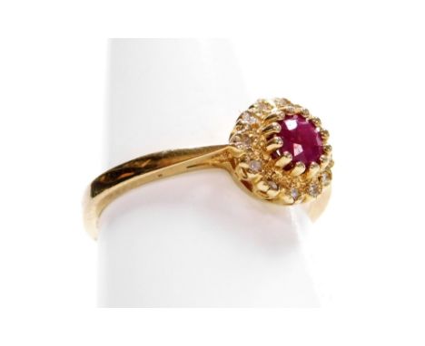 A 9ct gold ruby and diamond cluster ring, with central raised ruby approx 0.4cts, surrounded by twelve tiny diamonds, in a cl