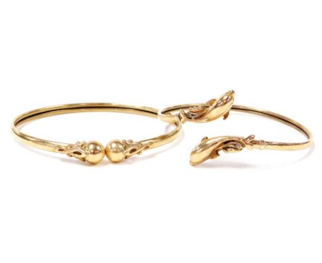 Two 9ct gold bangles, comprising a dolphin hinged bangle and a ball design torc bangle, 5cm and 6cm diameter, 15g all in.