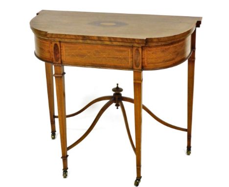 An Edwardian mahogany and satinwood cross banded demi lune fold over card table, with a green baize interior, raised on taper