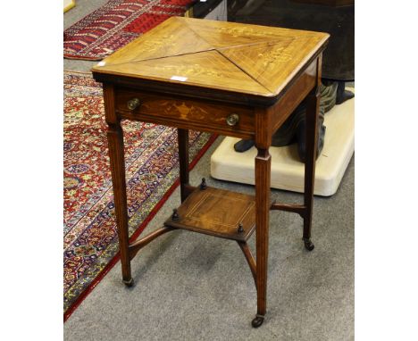 An Edwardian mahogany envelope card/games table, the revolving top section comprising four separate rosewood triangular leave