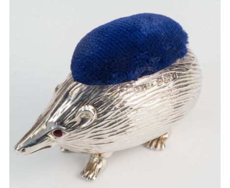 An Edwardian silver novelty hedgehog pin cushion, Adie & Lovekin Ltd., Birmingham 1908, with inset ruby red eyes and blue vel