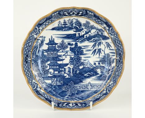 A blue and white transfer print pattern shallow bowl, late 19th century, scalloped gilt rim over stylised border, the main bo