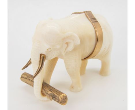 A miniature 9ct gold and ivory carved elephant, modelled as a working elephant carrying a gold log in its trunk, gold belt to