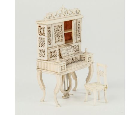 A 19th century carved ivory and bone miniature pianola cabinet and chair, French or Indian, the pianola on four inswept conca