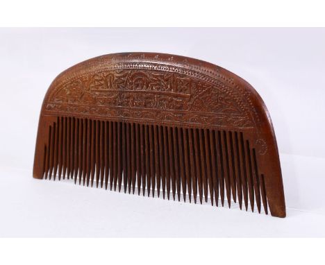 A 19TH CENTURY PERSIAN WOOD COMB CARVED WITH CALLIGRAPHY, 17cm wide.