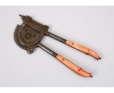 A 19TH CENTURY INDIAN STAINED IVORY HANDLE BEETLE NUT CRACKER, 17cm.