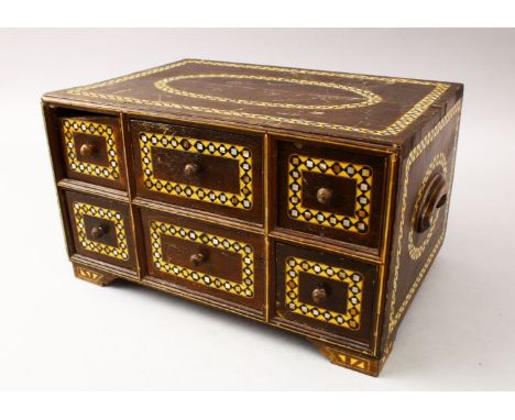 A GOOD 19TH CENTURY INDIAN WOODEN BOX, with six drawers and band of inlaid mother of pearl, 34cm wide x 23cm deep.
