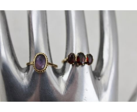 TWO 9CT GOLD LADY'S DRESS RINGS, one set with three cut garnets, the other an oval amethyst, total weight 5.3g 