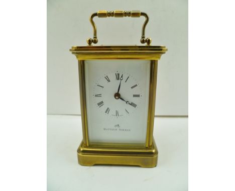 A "MATTHEW NORMAN" BRASS CASED CARRIAGE CLOCK, white enamel dial with Roman numerals, 11.5cm high, with key 