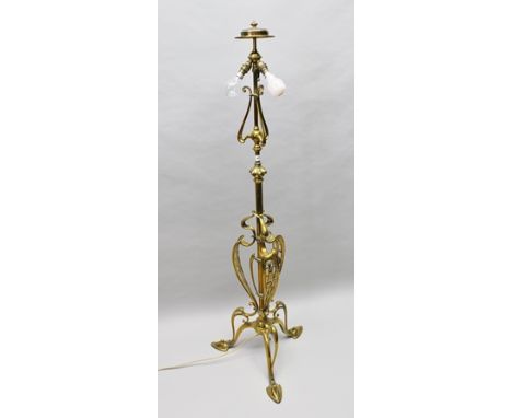 AN ART NOUVEAU BRASS STANDARD LAMP, having sinuous pierced floral decoration, supported on three spade shaped feet, 154 high 