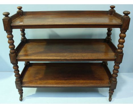 A late Victorian mahogany three-tier buffet, with three quarter gallery, turned bobbin supports and ceramic castors. 121cm wi