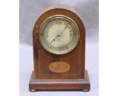 An Edwardian mahogany mantel aneroid barometer, with a circular, silvered dial and the case with domed top, inlaid with a mot