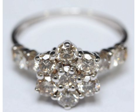 A 9ct white gold diamond cluster ring modelled as a flower and set with eleven RBC diamonds, VS clarity, Approximate total di