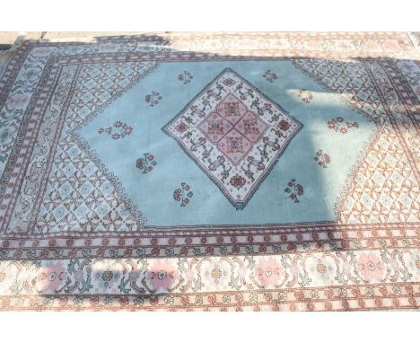 A Turkish Kula geometric carpet, decorated with flowers and patterns around a central diamond on a blue ground. 214 x 320 cm.